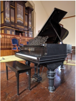 The Steinway grand piano in the sanctuary, with the organ behind it
